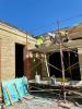 Workers installing final limestone facing over future front entrance, July 23, 2025