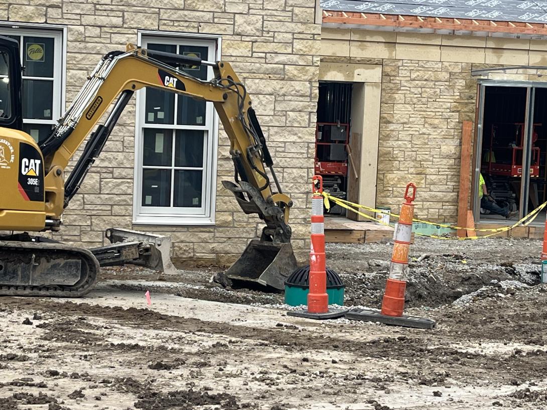 Excavator fills in trench dug for drainage pipes, September 23, 2025