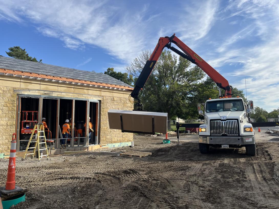Truck crane unloading drywall into the building, September 24, 2025
