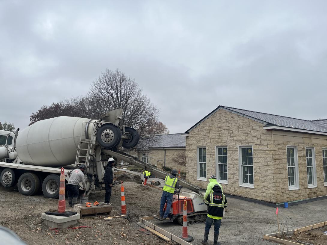 Pouring cement into a rolling bucket for sidewalks in front of the Museum, November 18, 2025
