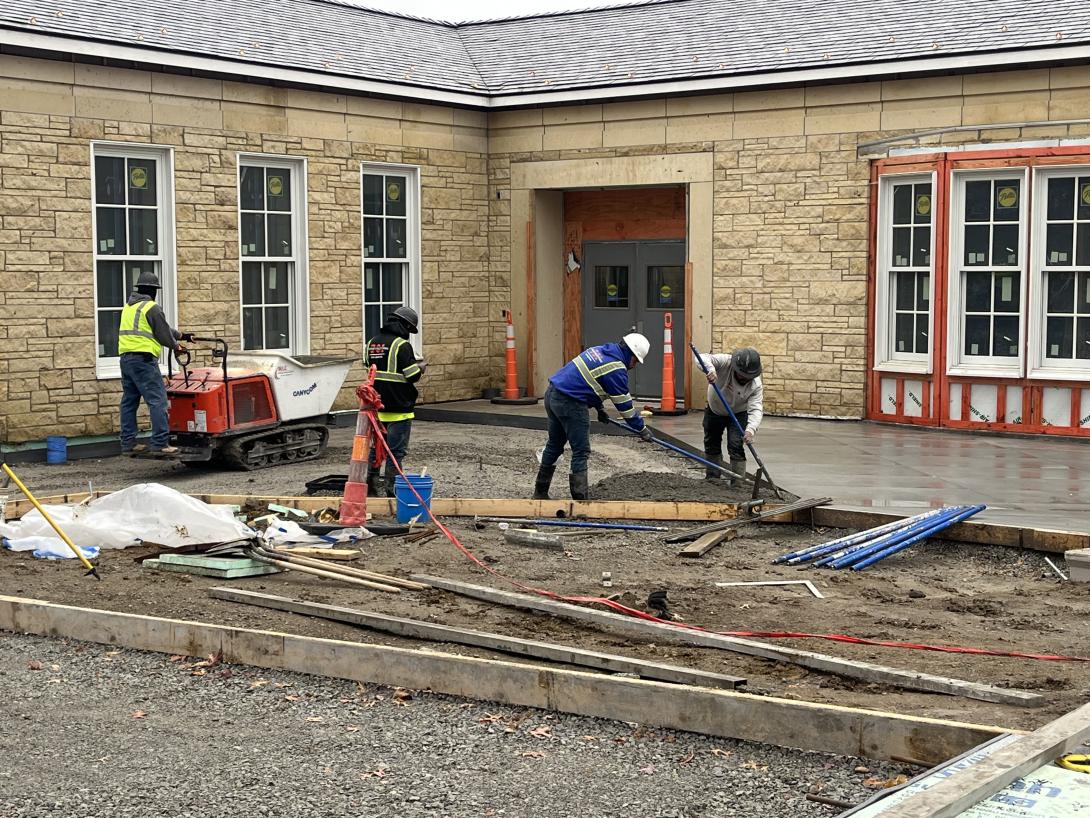 Spreading concrete for sidewalks in front of the Museum, November 18, 2025