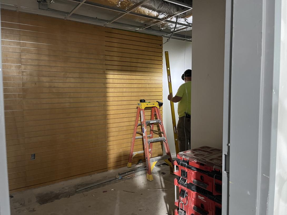 Slat boards from old gift shop being installed in gift shop storage room, January 21, 2026