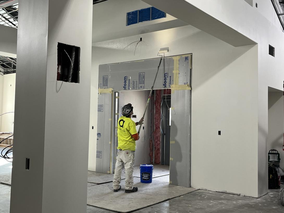 Worker paints new lobby area, February 11, 2026