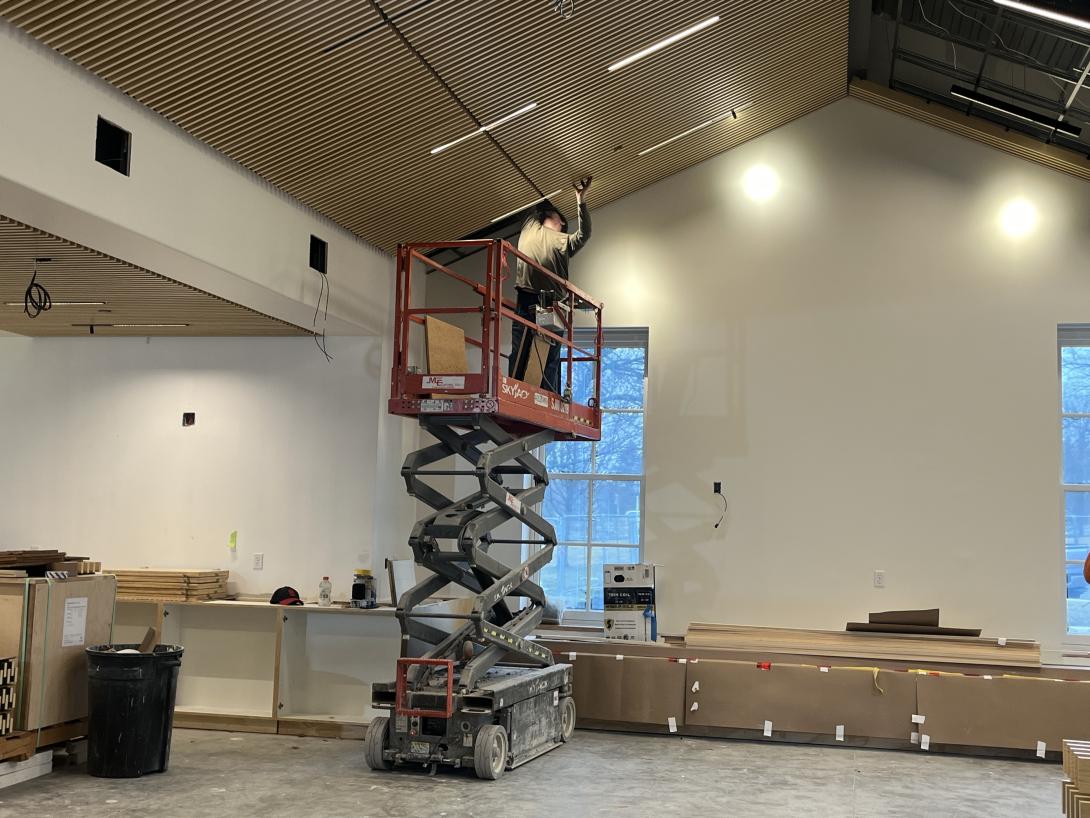 Worker installs ceiling panels in gift shop, March 11, 2026