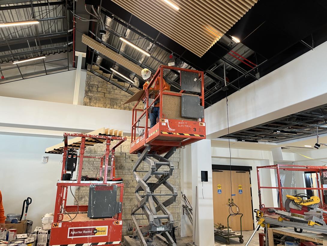 Worker installs ceiling panels in Museum lobby, March 18, 2026