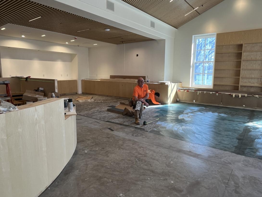 Workers lay new carpet in gift shop, April 8, 2026
