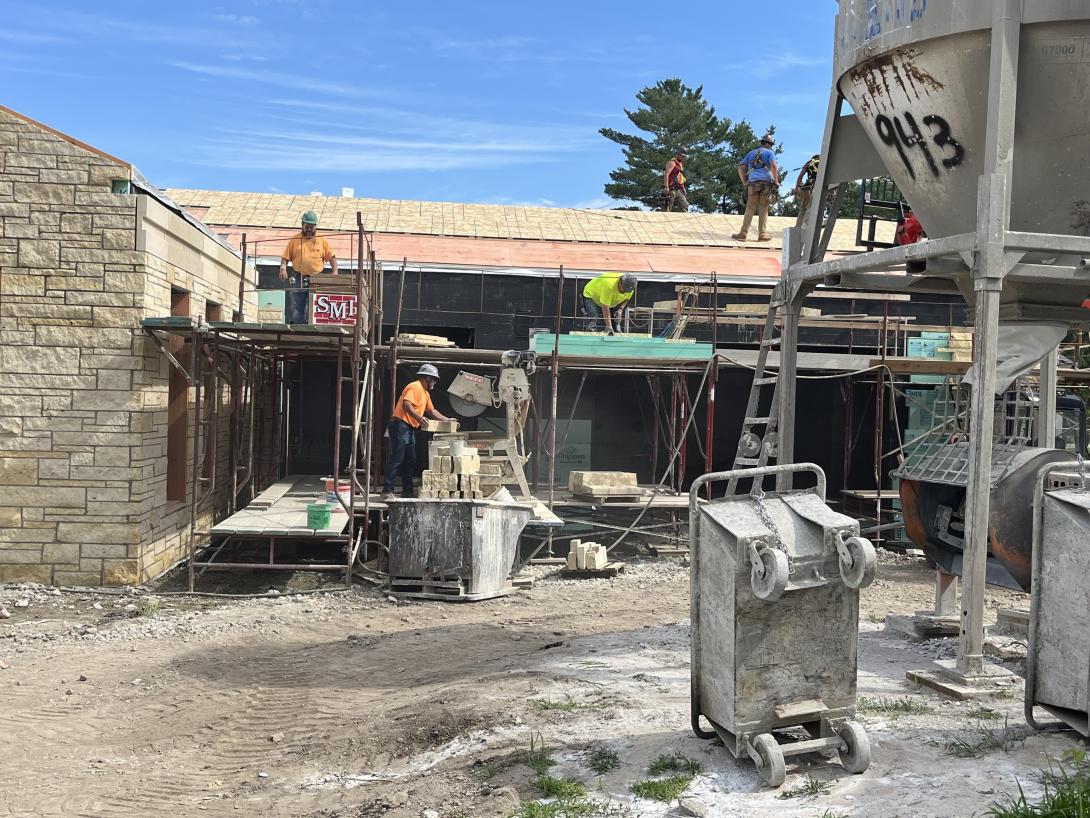 Worker saws limestone blocks into smaller pieces for Museum exterior, July 2, 2025