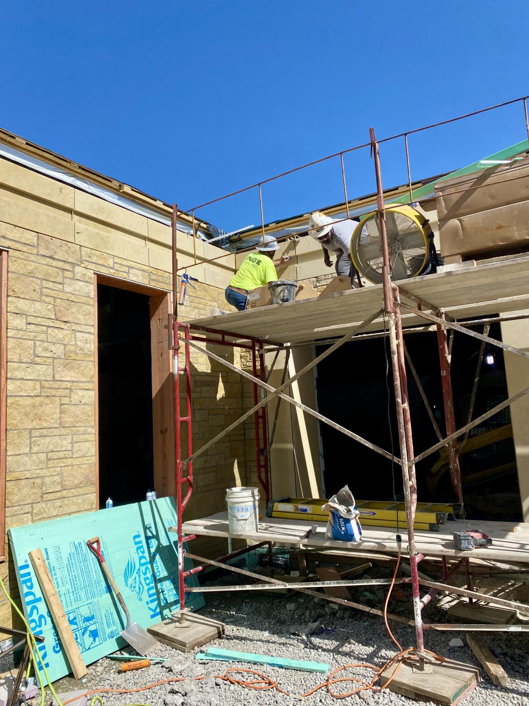 Workers installing final limestone facing over future front entrance, July 23, 2025