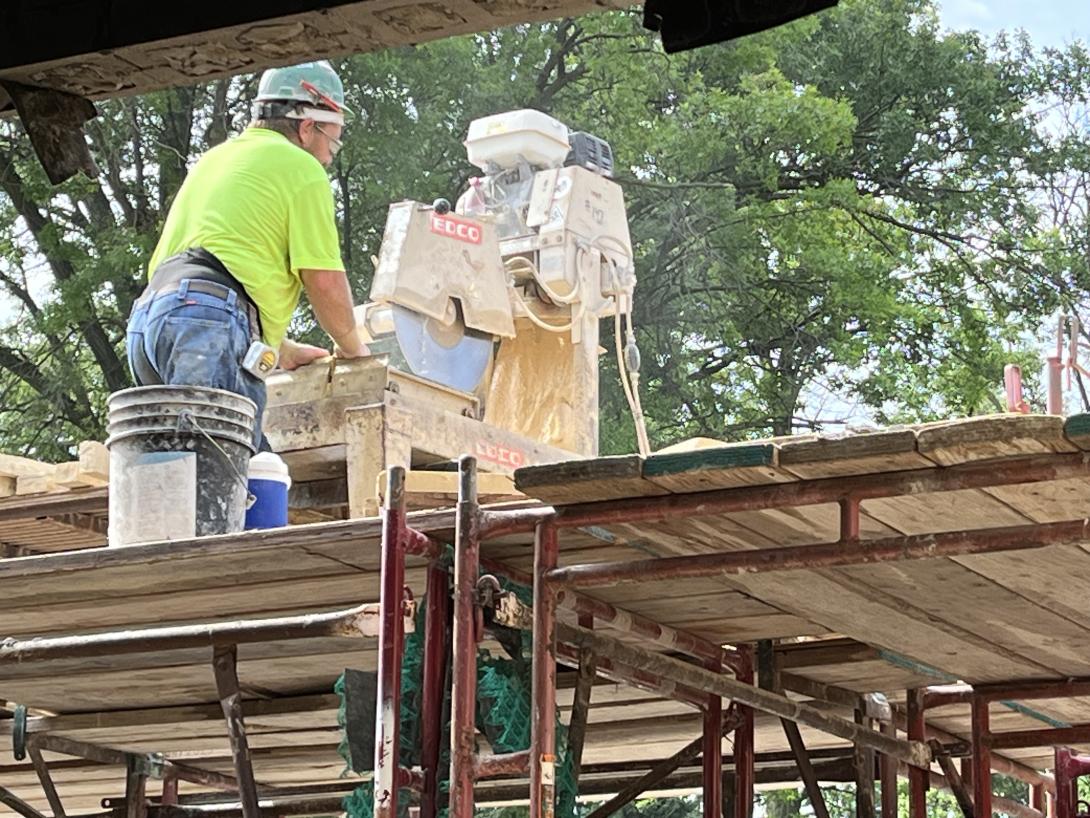 Worker saws limestone into brick-size pieces for Museum façade
