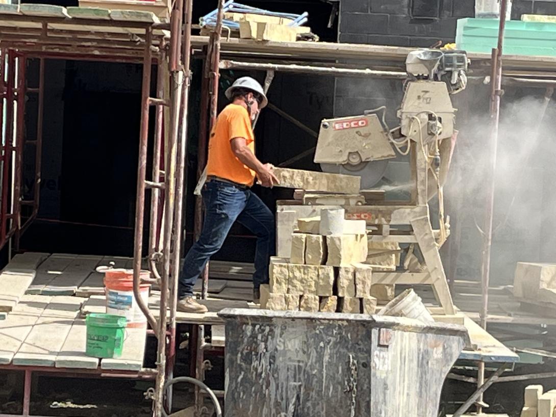 Worker sawing limestone for Museum exterior